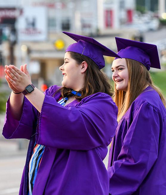Mattie DeHaven and Kathryn Rothermich look on as a parade of vehicles drive past